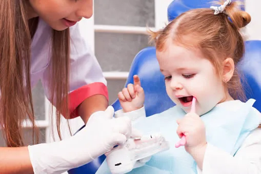 two-years-old-girl-is-learning-brush-her-teeth-with-toothbrush-hand-dental-office young